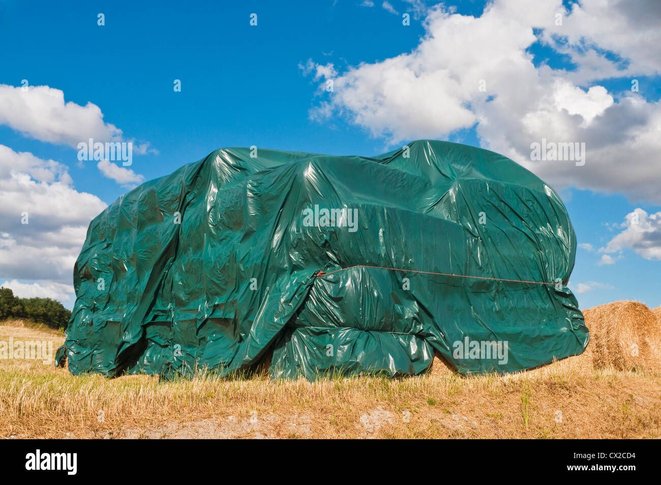 Stapel von Strohballen abgedeckt im schützenden Plastikplanen - Sud-Touraine, Frankreich. Stockfoto
