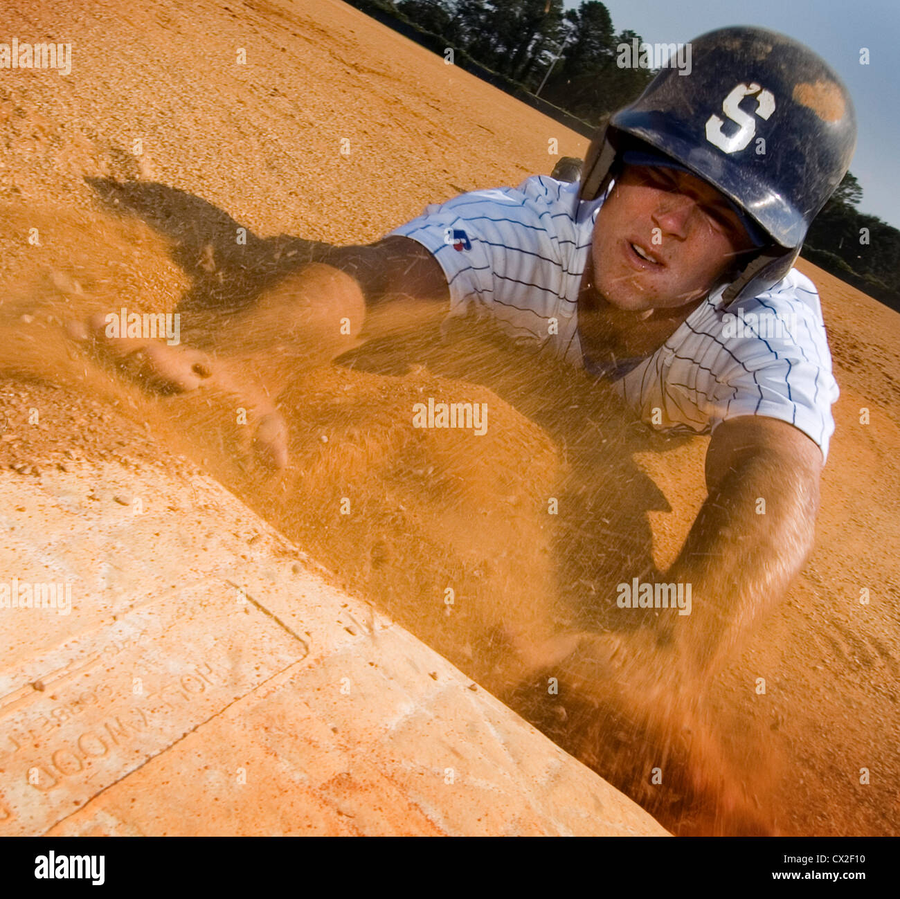 Einen Helm tragen College Baseball Spieler gleitet in dritten Base auf einem Feld Schule Stockfoto
