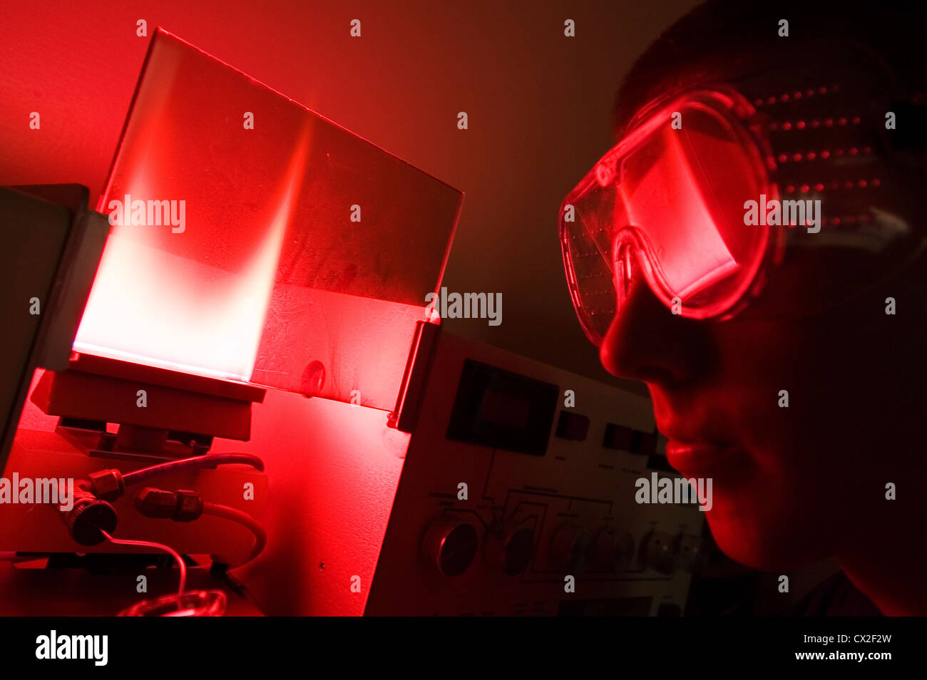 Ein College-Student im roten Schein der einen Gaschromatographen gebadet Stockfoto