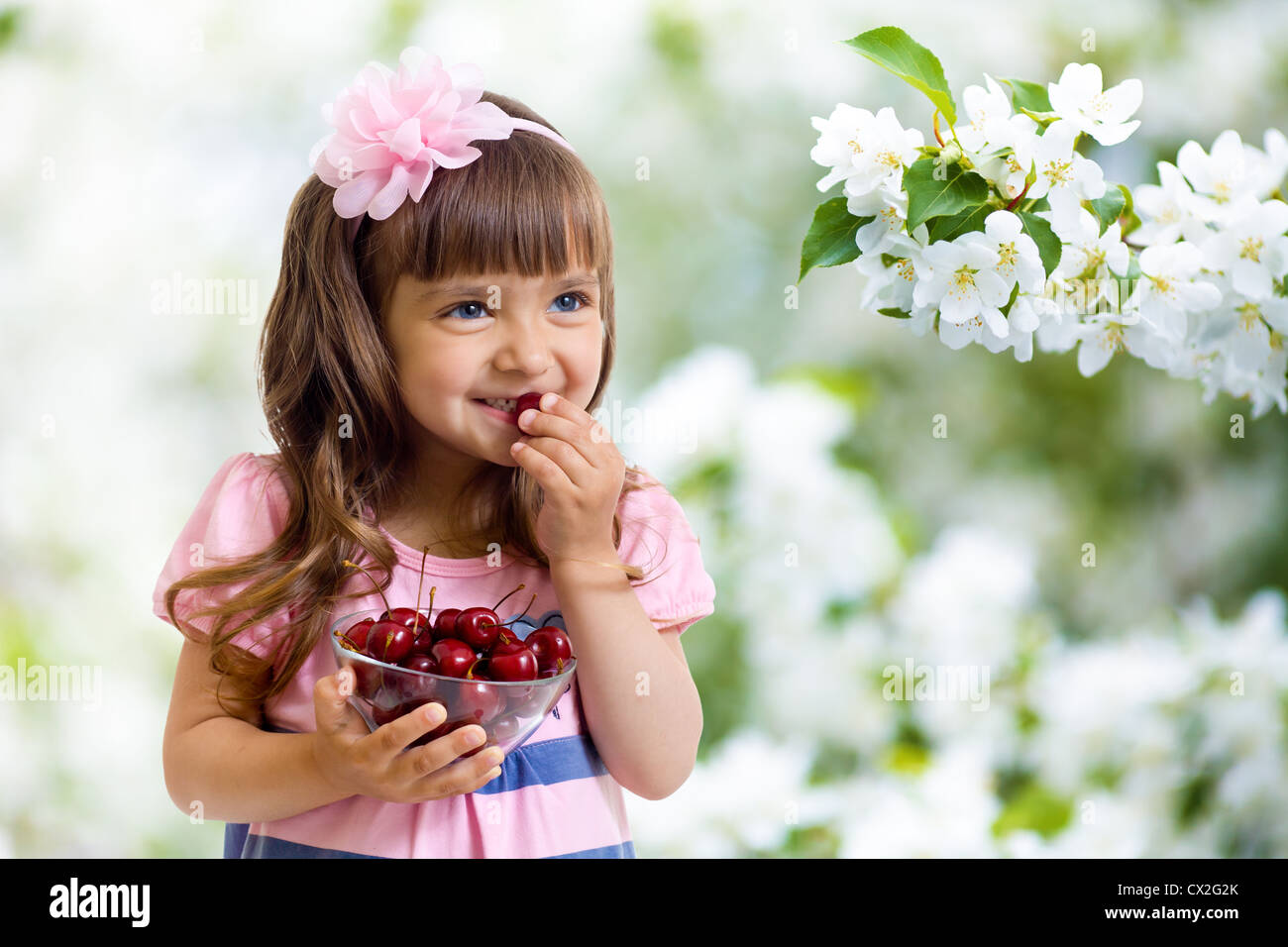 kleines Mädchen mit Kirsche Beeren Schüssel im Studio isoliert Stockfoto