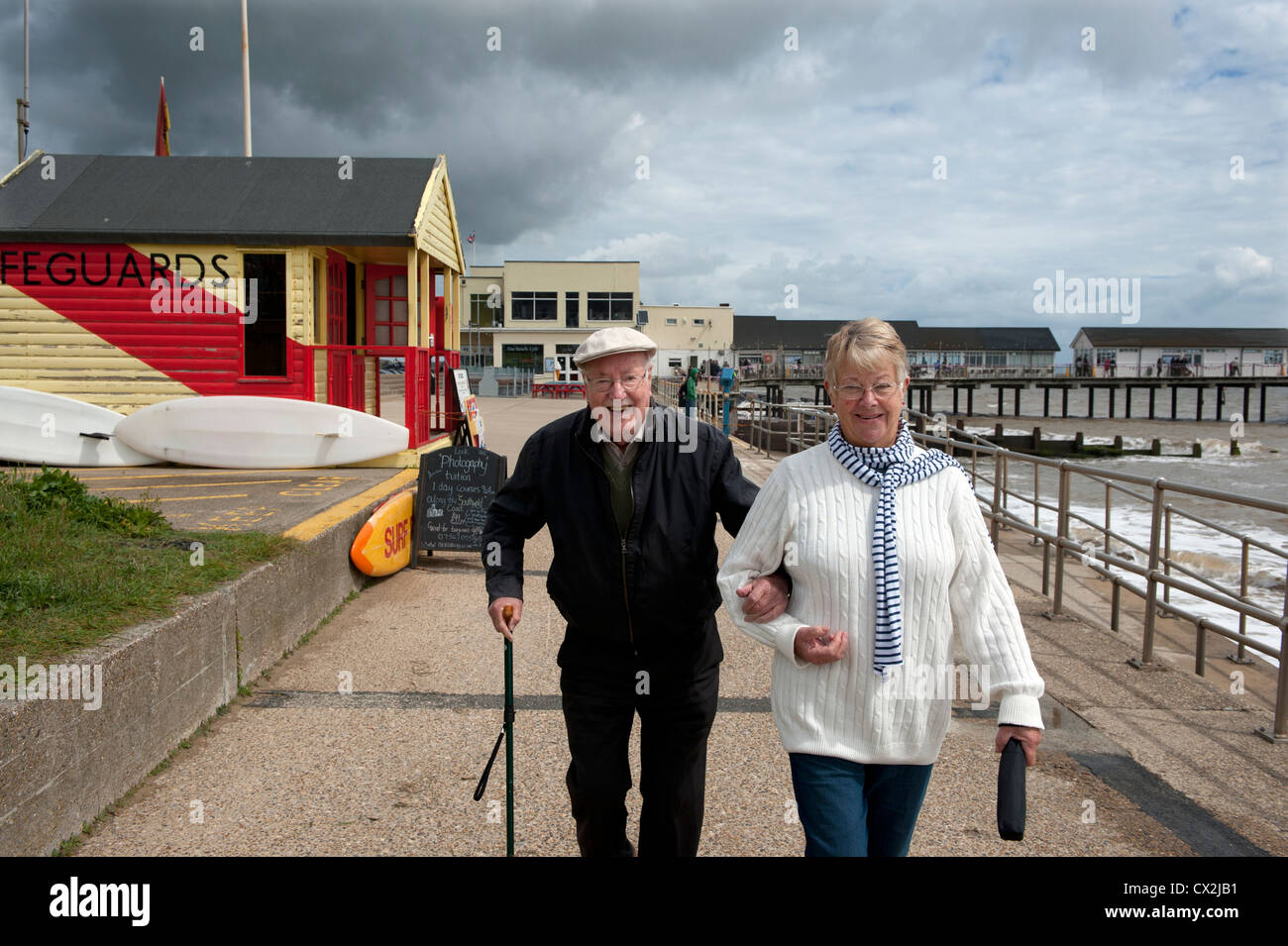 Älterer Mann und Frau zu Fuß entlang der Front in Southwold, Suffolk, England. Senioren wandern. Stockfoto