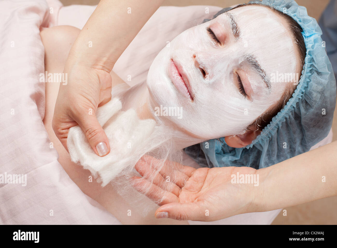 Seide Maske anwenden, Schönheit Behandlung junge Frau Gesicht im salon Stockfoto