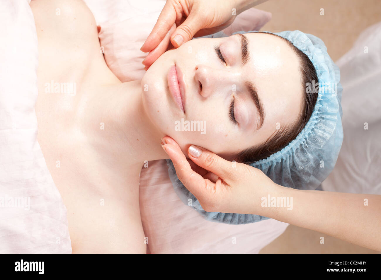 Schöne Frau mit klare Haut bekommen Beauty-Behandlung - Massage ihr Gesicht im salon Stockfoto