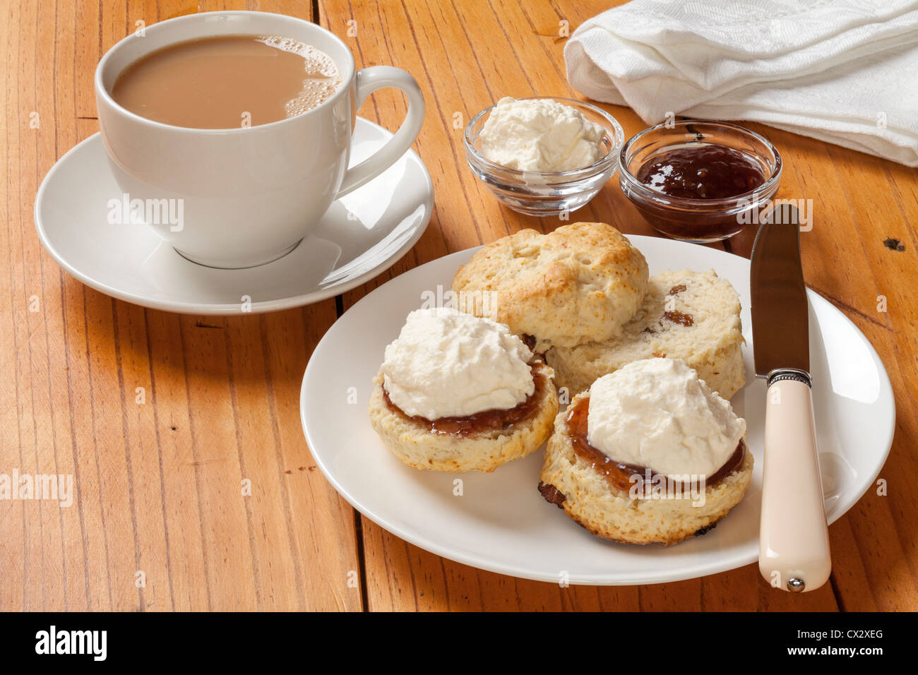 Devon Cream Tea, Scones, Marmelade, Sahne und einer Tasse Tee auf einer alten Kiefer Tisch. Stockfoto