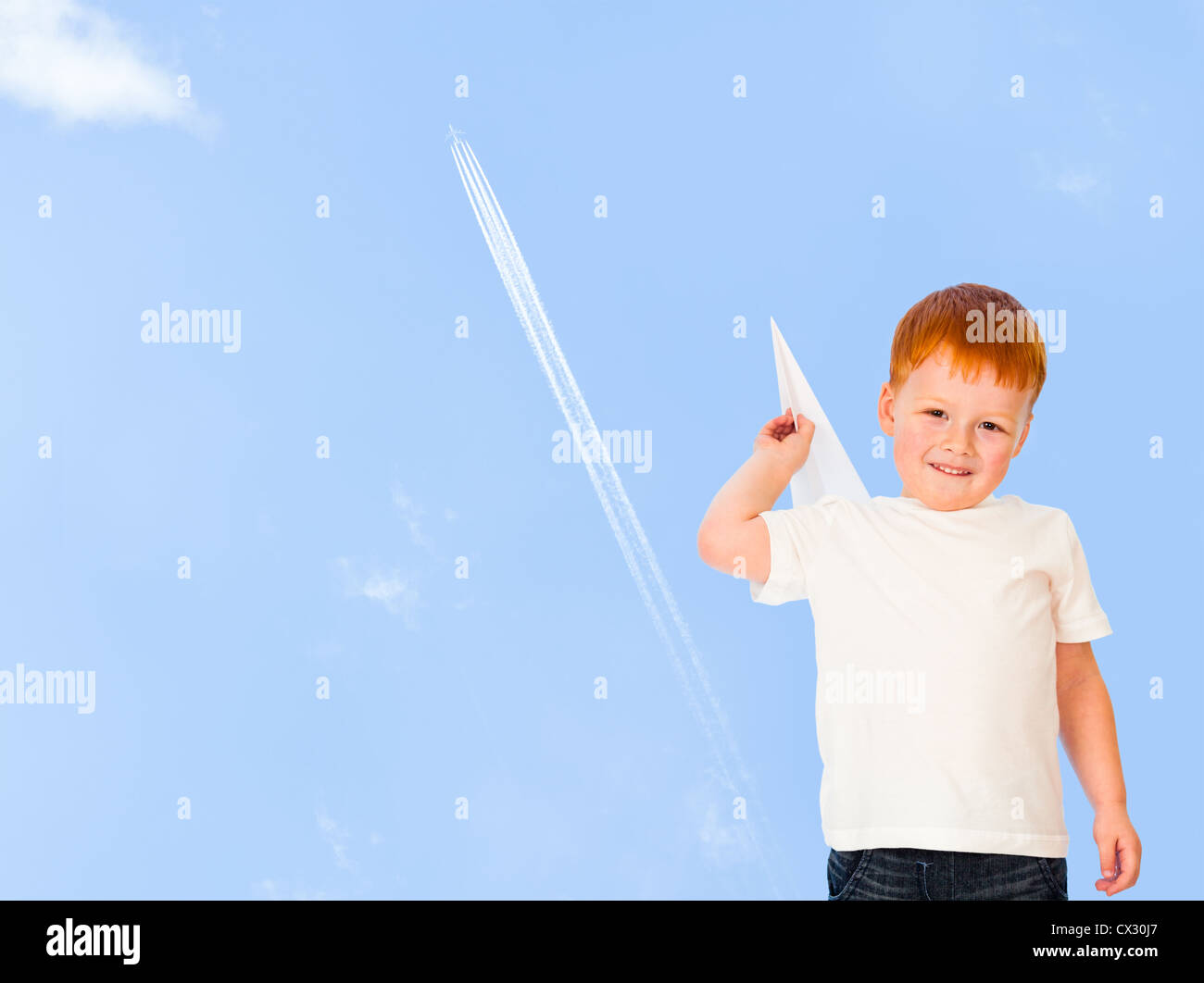 Bezaubernde rothaarige junge mit Papier Flugzeugmodell auf blauen Himmel Stockfoto