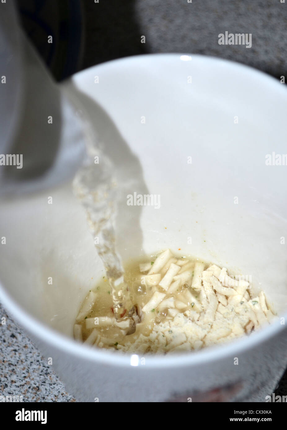 gießen kochendes Wasser auf WM-Suppennudeln Stockfoto