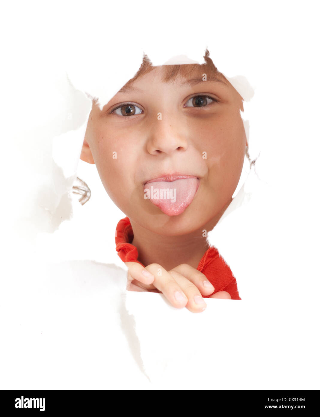 lustiges Kind zeigt Zunge in zerrissenes Papier Loch isoliert Stockfoto