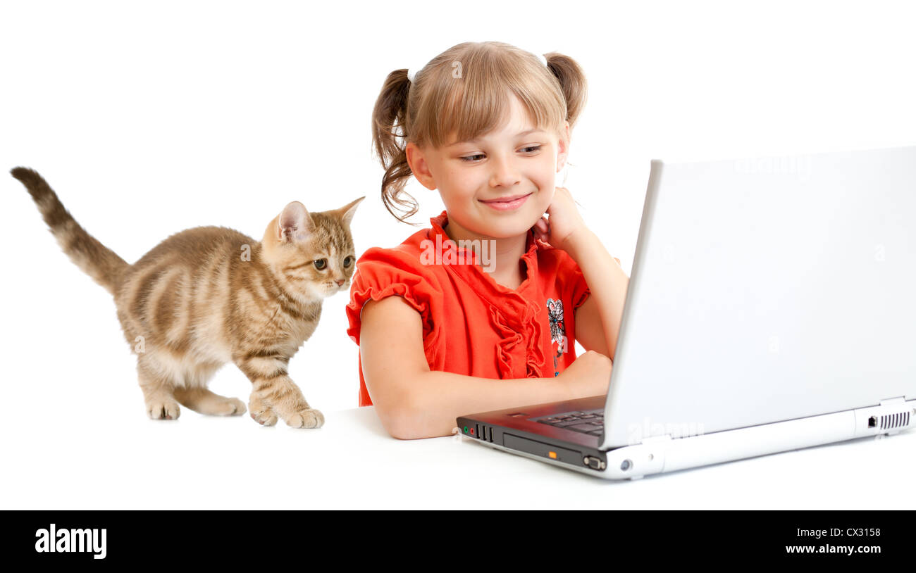 lächelnde Schulmädchen sitzen am Notebook mit Kätzchen Stockfoto