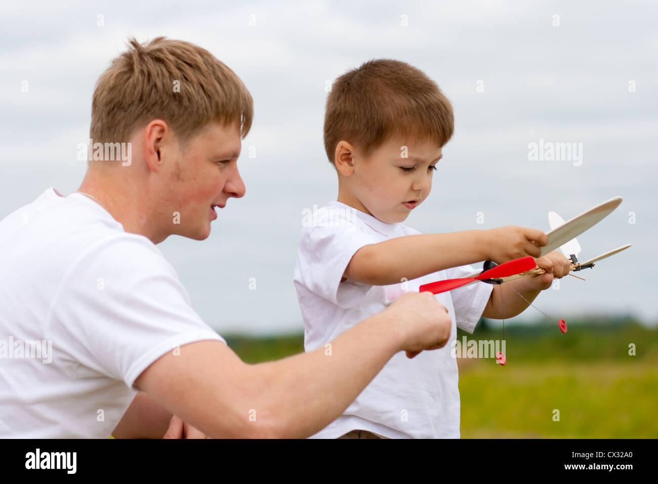 Vater und Sohn haben Spaß mit Spielzeug Flugzeugmodell im park Stockfoto