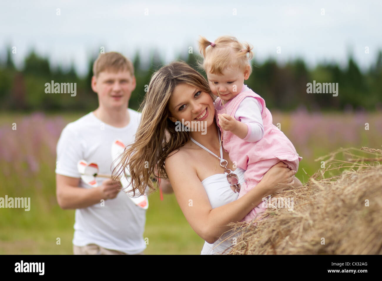 Glückliche Mutter und Tochter mit Vater im Hintergrund Stockfoto