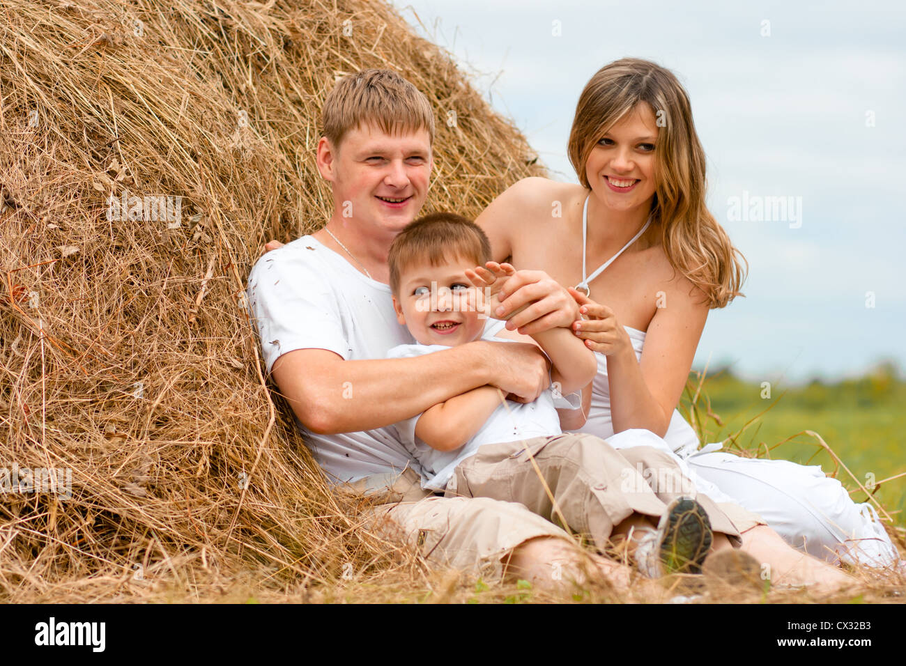 Glückliche Familie hat Spaß im Heuhaufen zusammen Stockfoto