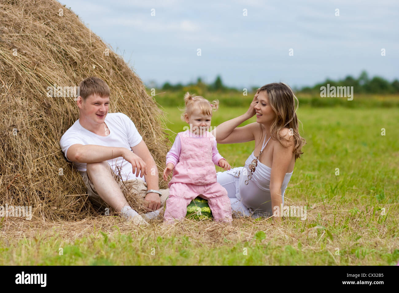 Happy Family im Heuhaufen oder Heuschober mit Wassermelone Stockfoto