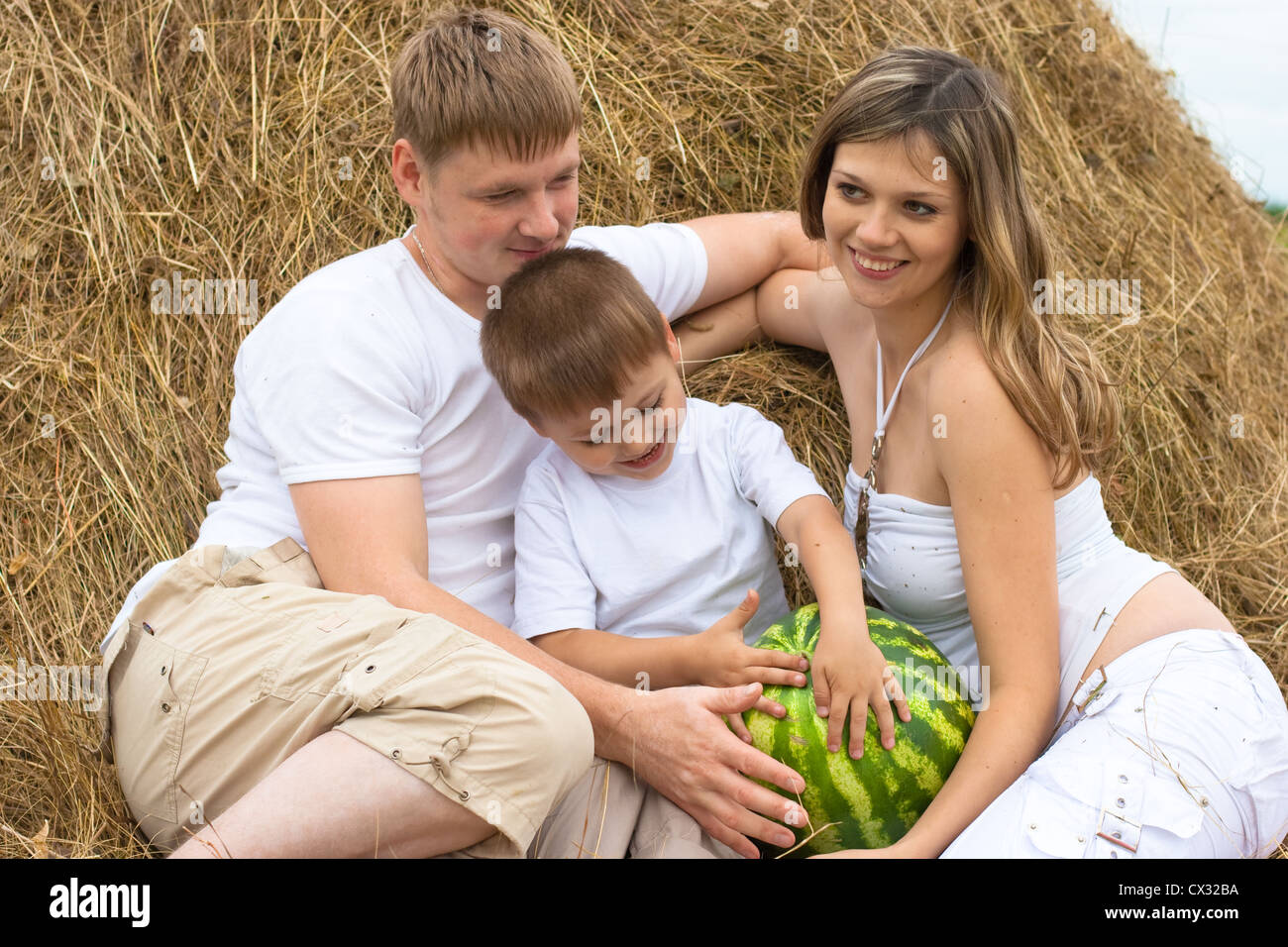 Happy Family im Heuhaufen oder Heuschober mit Wassermelone Stockfoto