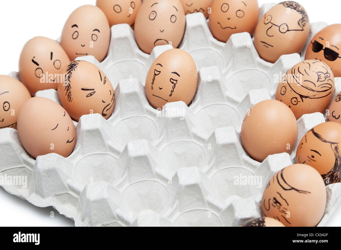 Vielfalt von Gesichtsausdrücken auf braunen Eiern angeordnet im Karton gemalt Stockfoto