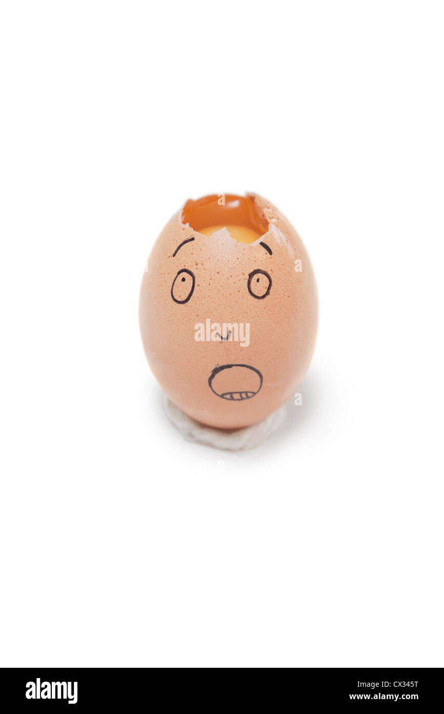 Gebrochene Ei mit Gesicht drauf auf weißem Hintergrund Stockfoto