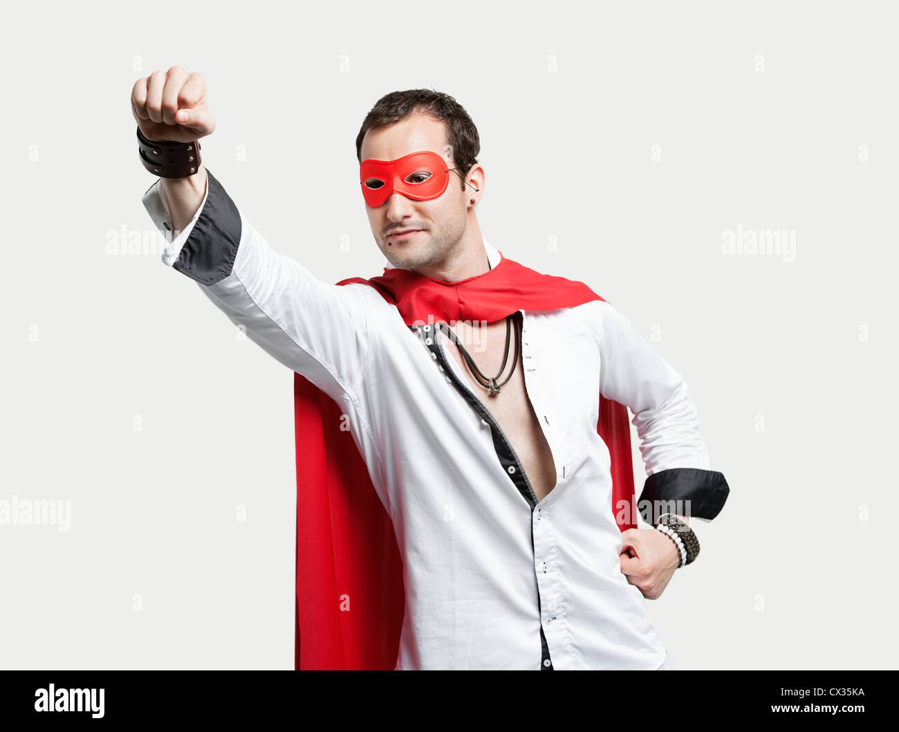 Junger Mann Superhelden-Kostüm vor grauem Hintergrund Stockfoto