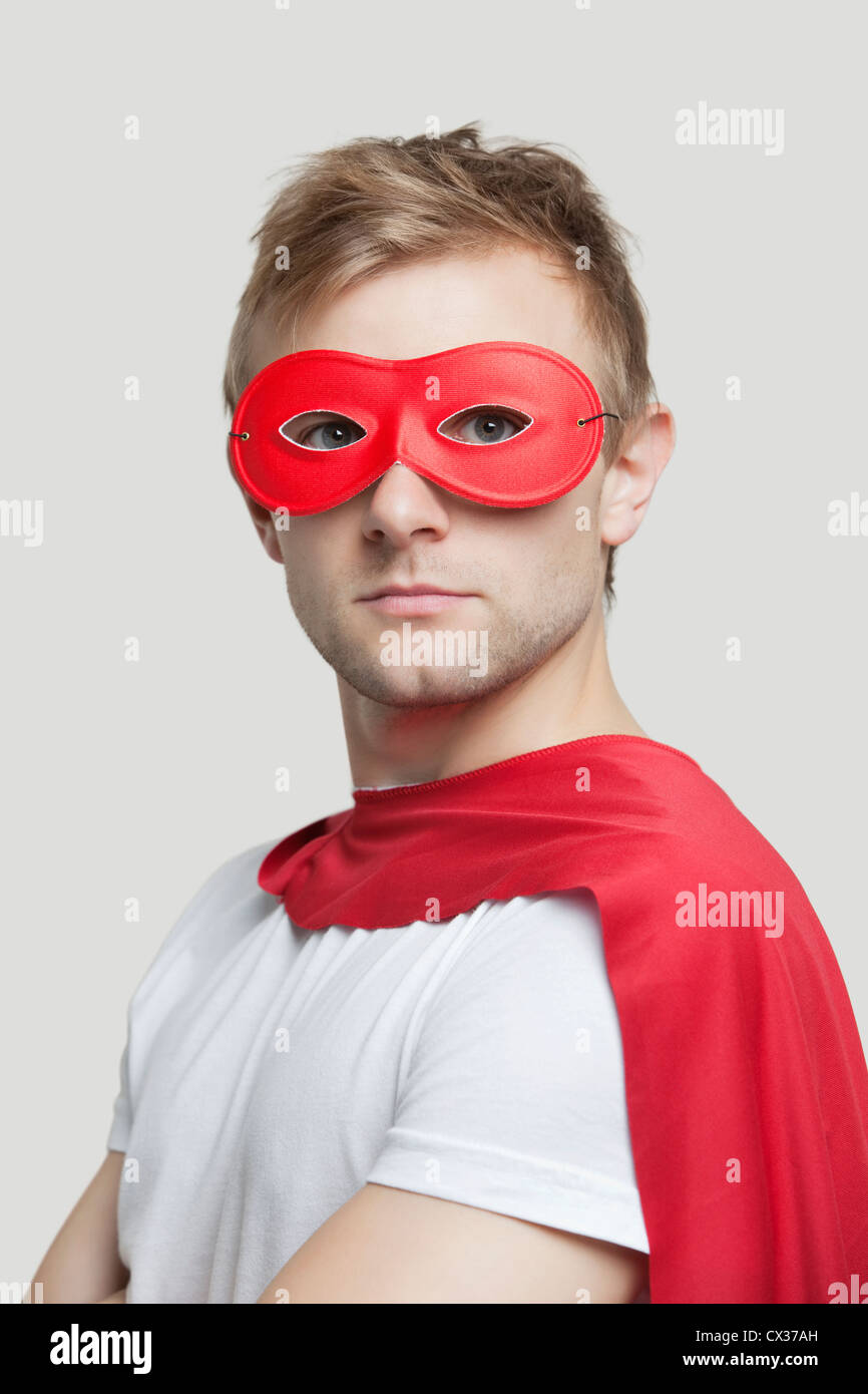 Porträt des jungen Mannes Superhelden-Kostüm vor grauem Hintergrund Stockfoto