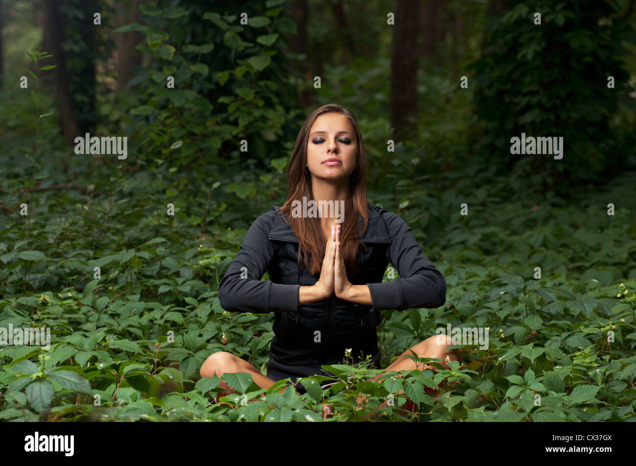 Schöne attraktive Mädchen im Freien zu meditieren, in Lotus-pose Stockfoto