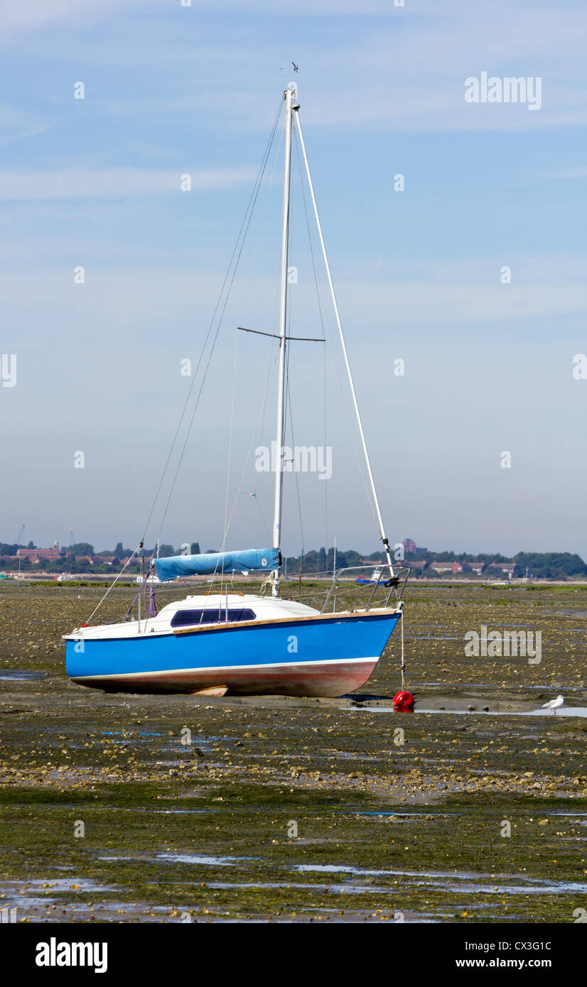 Blaues Boot bei Ebbe mit Mast, und rote Bouy festgemacht Stockfoto