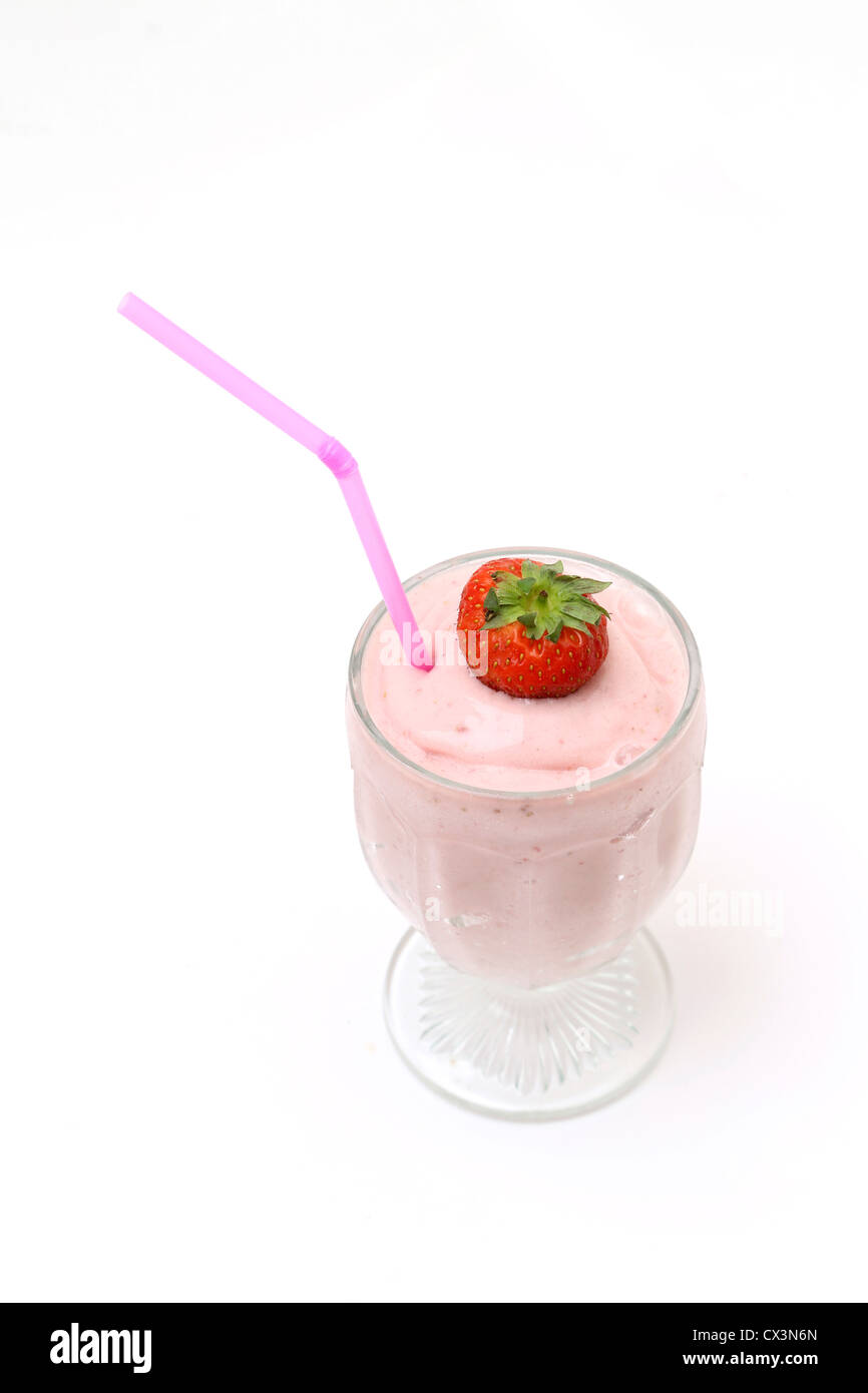 Erdbeer Milchshake In ein Glas mit Erdbeeren und Stroh Stockfoto