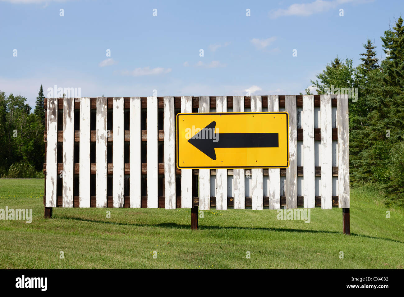 Richtungspfeil Zeichen auf einem weißen Zaun. Stockfoto