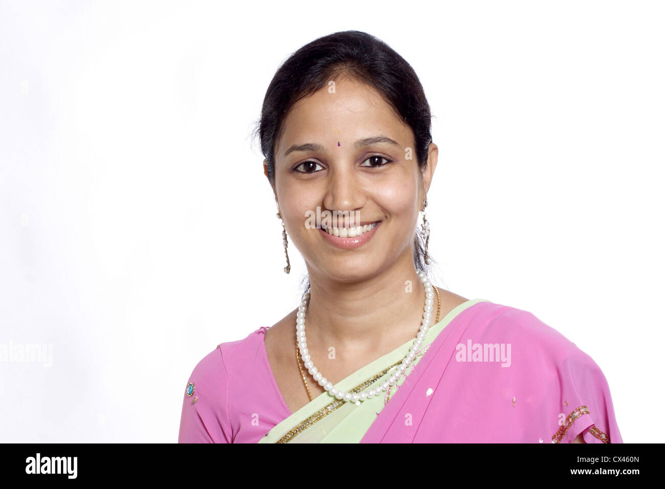 Lächelnde junge indische traditionelle Frau vor weißem Hintergrund Stockfoto