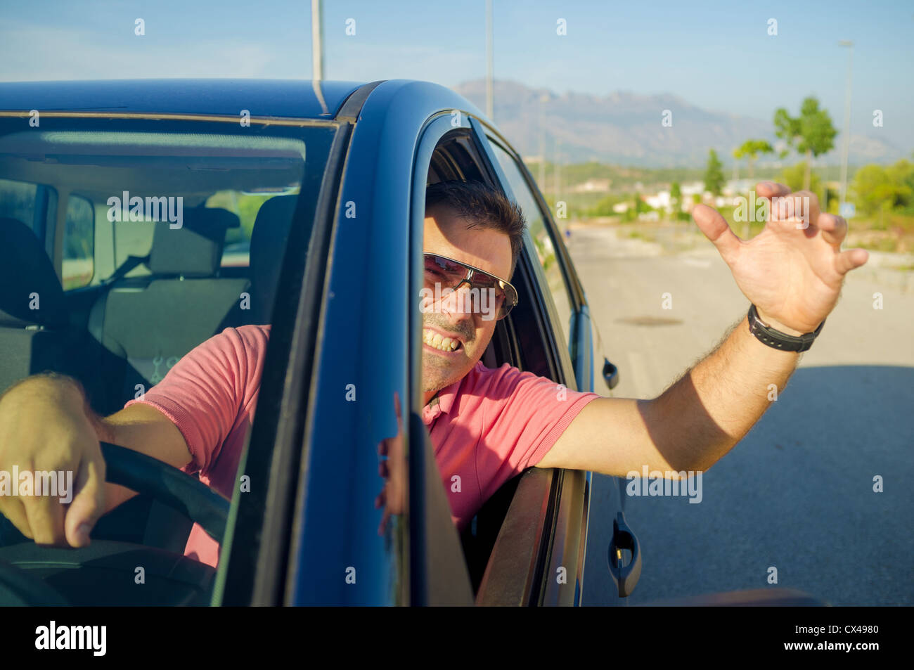 Fahrer aus seinem Auto Fenster gestikulierend hängen Stockfoto