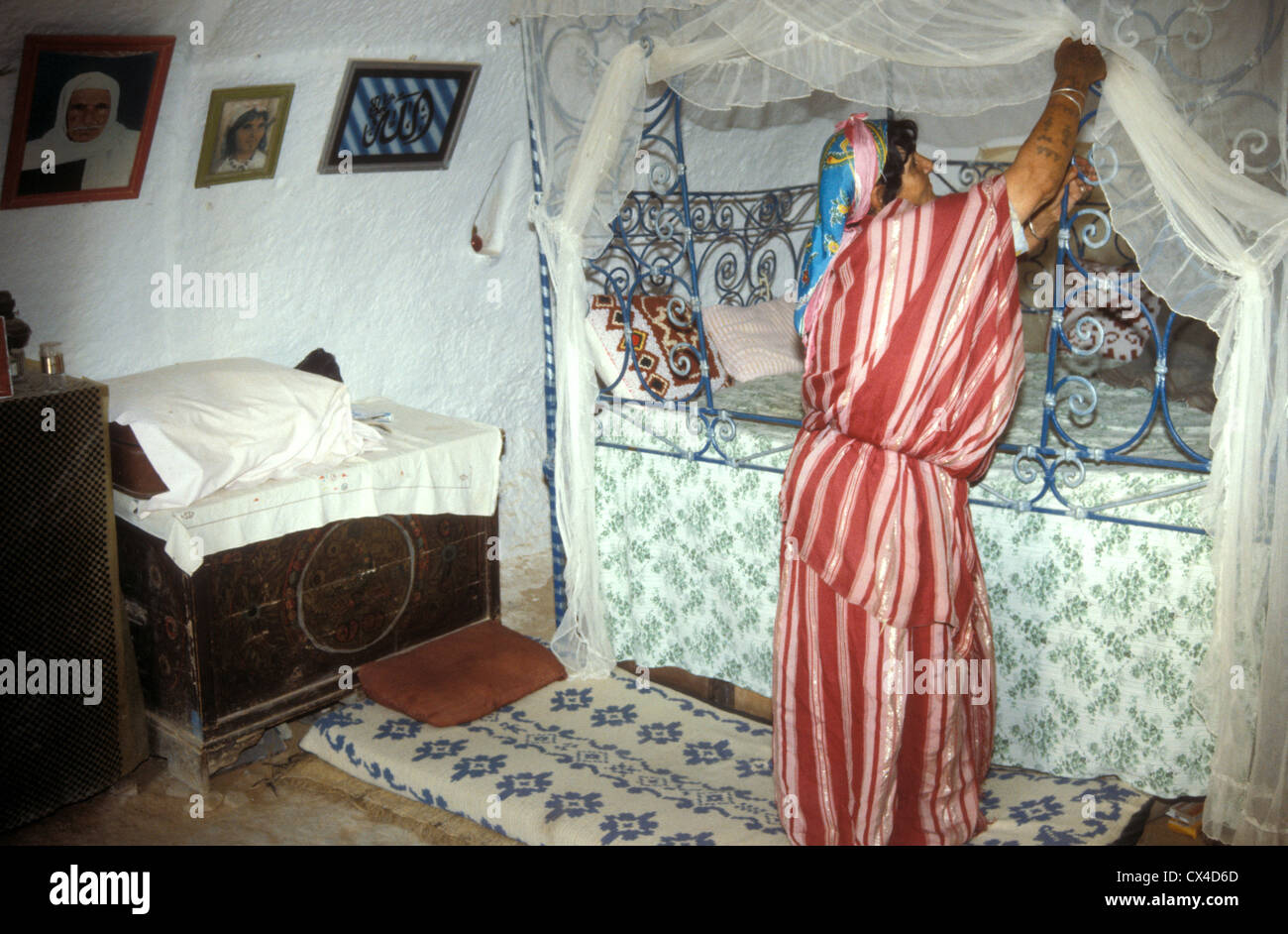 Berber Frau macht ihr Bett in einem unterirdischen Haus in Matmata Tunesien Stockfoto