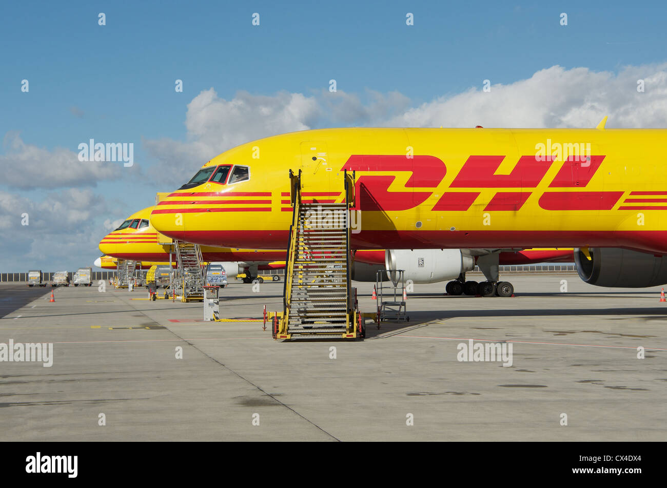Eine Reihe von gelben und roten DHL Boeing 757-200 SF Frachtflugzeugen Parken am Flughafen Leipzig in Deutschland Stockfoto