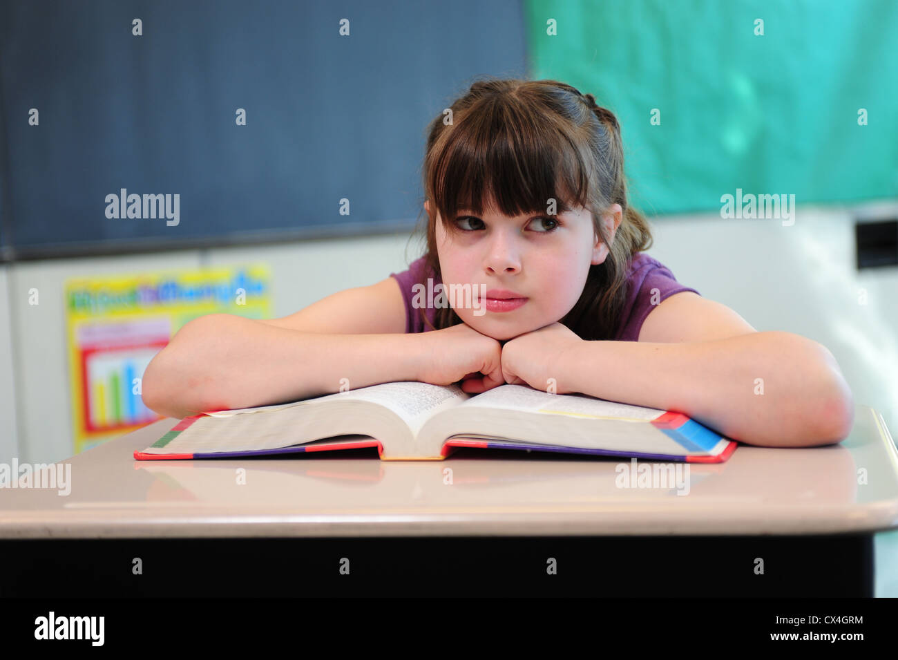 USA, die eine Dritter 3. Klasse Mädchen sitzt gelangweilt in einem Klassenzimmer an der öffentlichen Schule Stockfoto