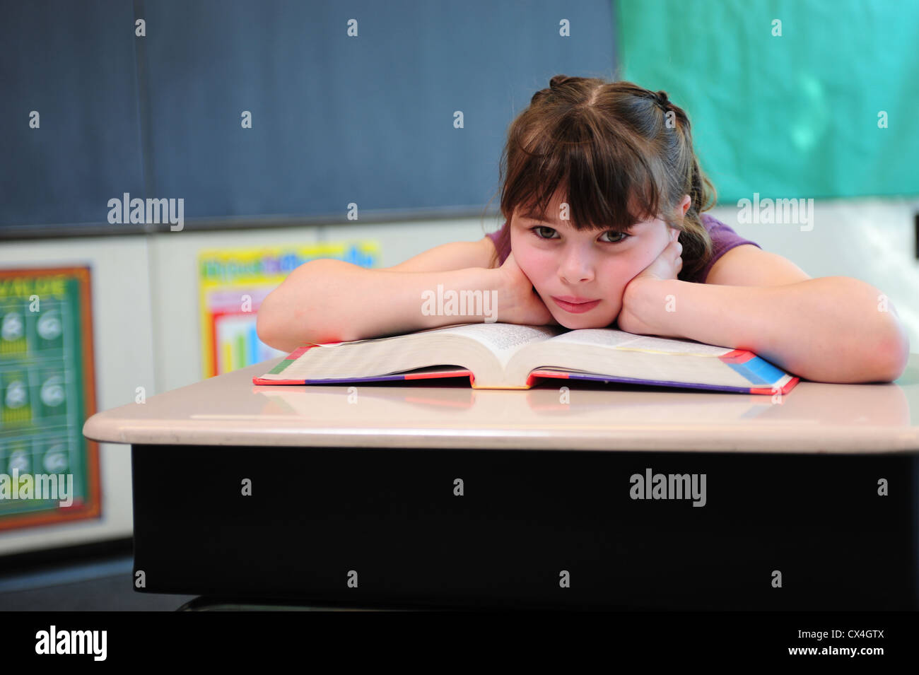 USA, die eine Dritter 3. Klasse Mädchen sitzt gelangweilt in einem Klassenzimmer an der öffentlichen Schule Stockfoto