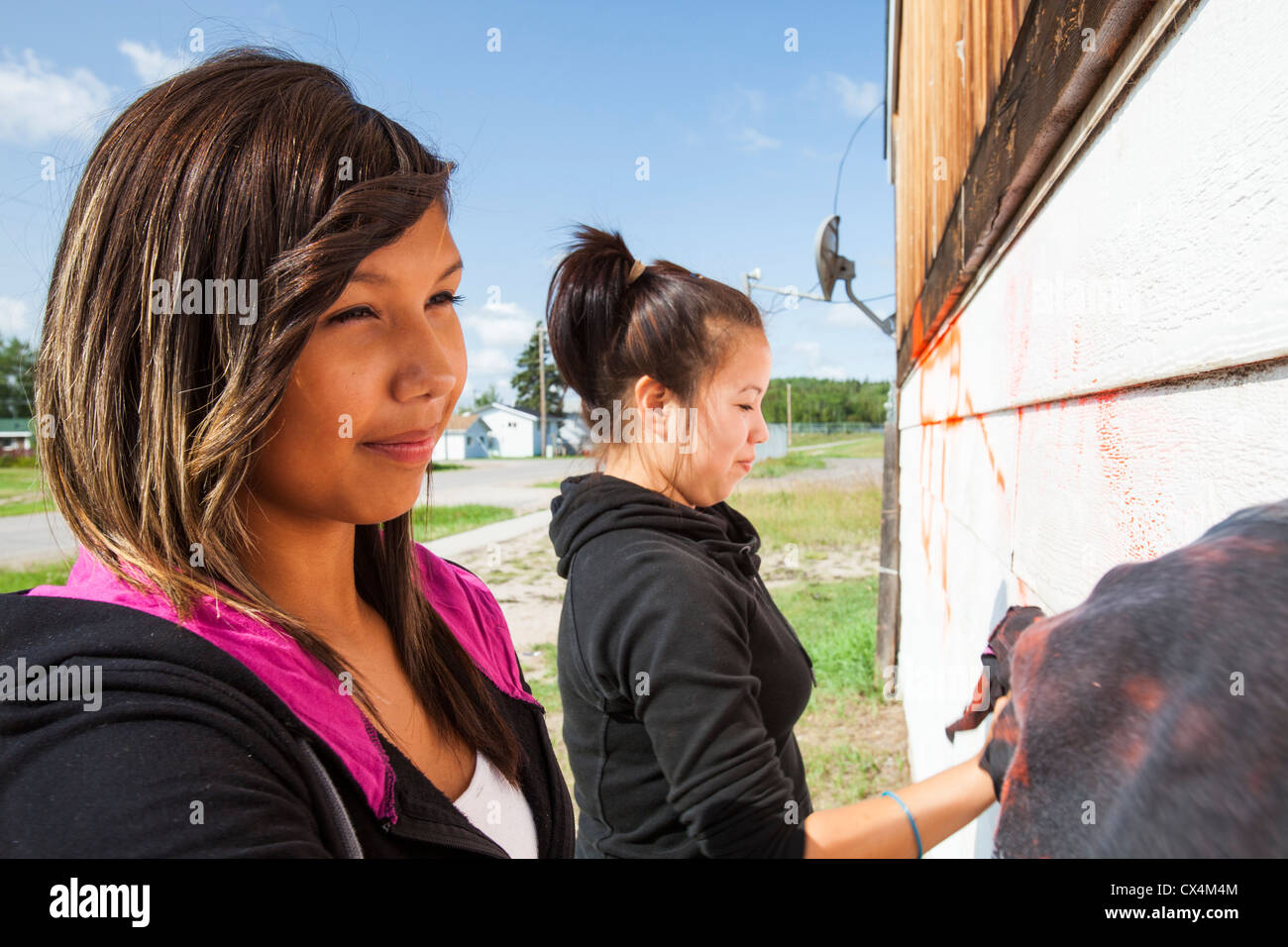 Erste Nation Mädchen im Teenageralter sauber Grafitti aus einem Haus im Fort Chipewyan. Stockfoto