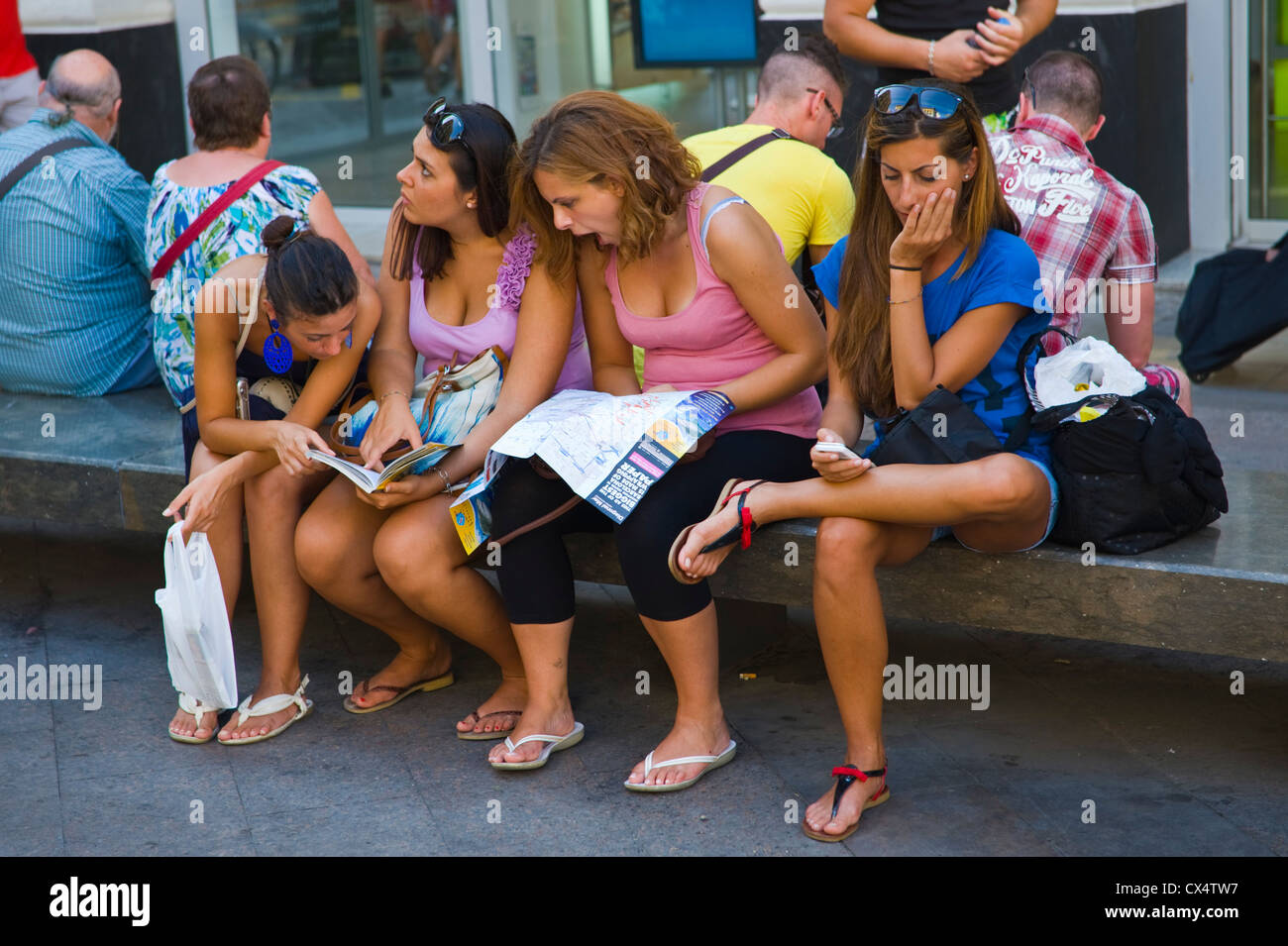 Junge Frauen Touristen saßen auf Bank Karte auf Straße in Barcelona Katalonien Spanien ES zu studieren Stockfoto