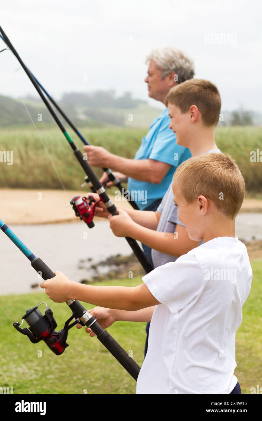 zwei Jungs mit ihrem Opa am Fluss angeln Stockfoto