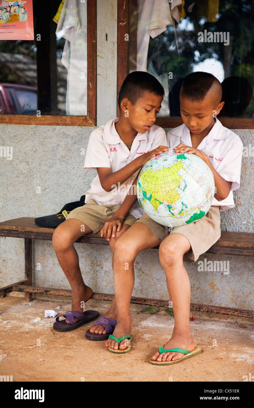 Thailändische Schüler studieren eine Weltkugel. Mae Hong Son, Mae Hong Son, Thailand Stockfoto