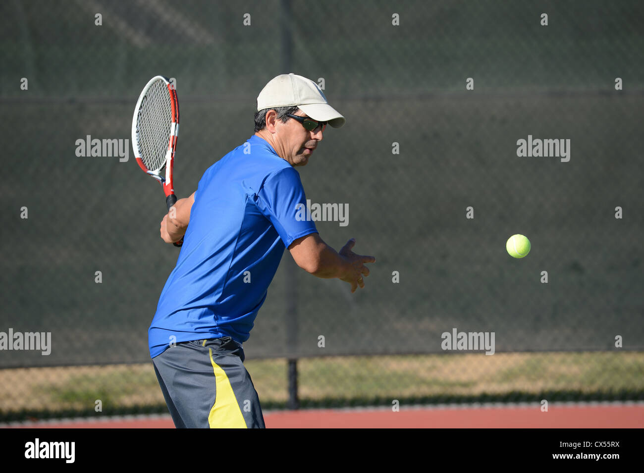 Senior-hispanischen Tennisspielen an sonnigen Tag Stockfoto