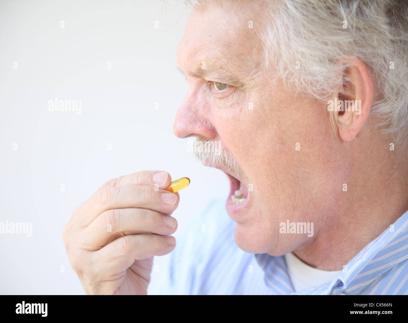 ein Mann mit einem Fisch-Öl-gelcap Stockfoto