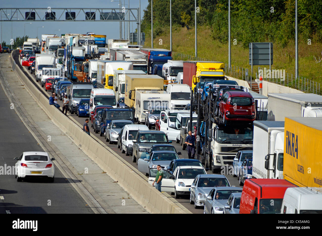 Blick von oben auf den stationären Verkehr, der auf vier Spuren der Autobahn M25 festgefahren ist. Einige Fahrer aus ihren Fahrzeugen Essex England UK Stockfoto