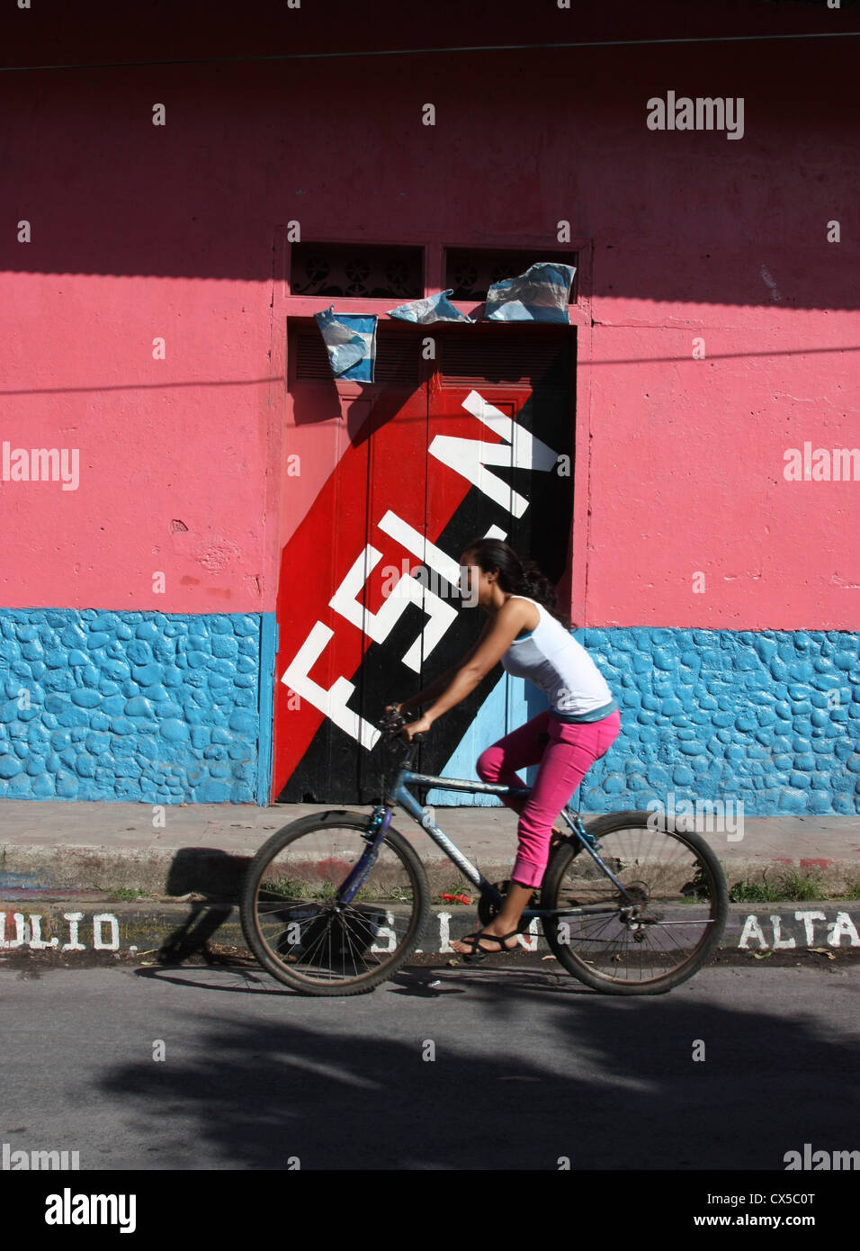 Mädchen Reiten Fahrrad vorbei Sandinista Wahl Schild in Ometepe Nicaragua Stockfoto