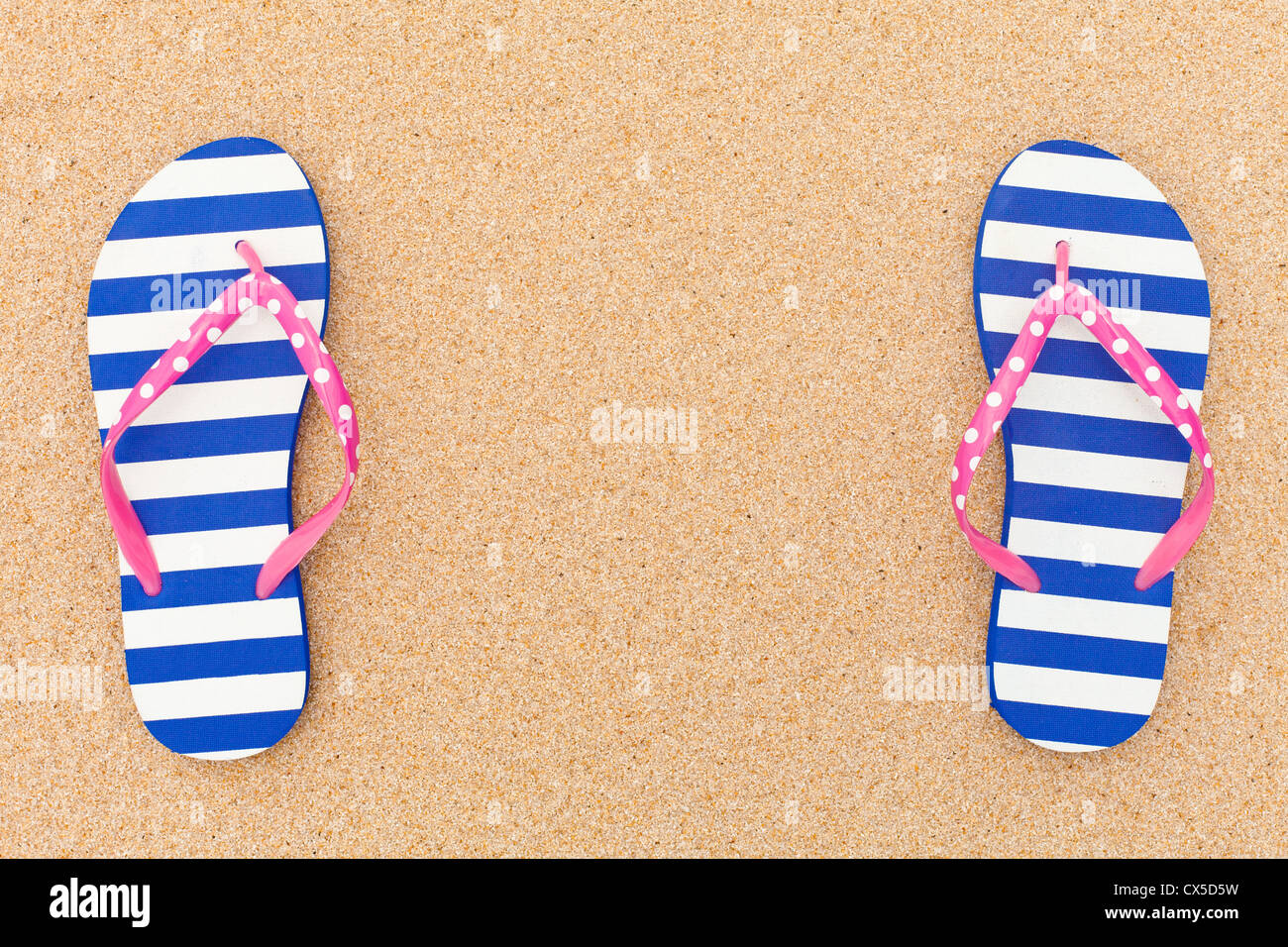 Bunte Flipflop Pairas einen Frame auf Strandsand Stockfoto