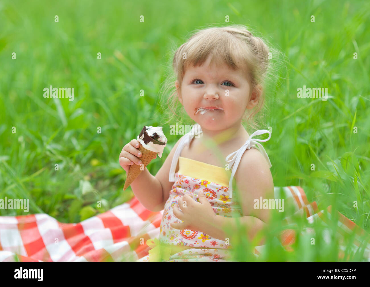 kleine Mädchen essen Eis im freien Stockfoto