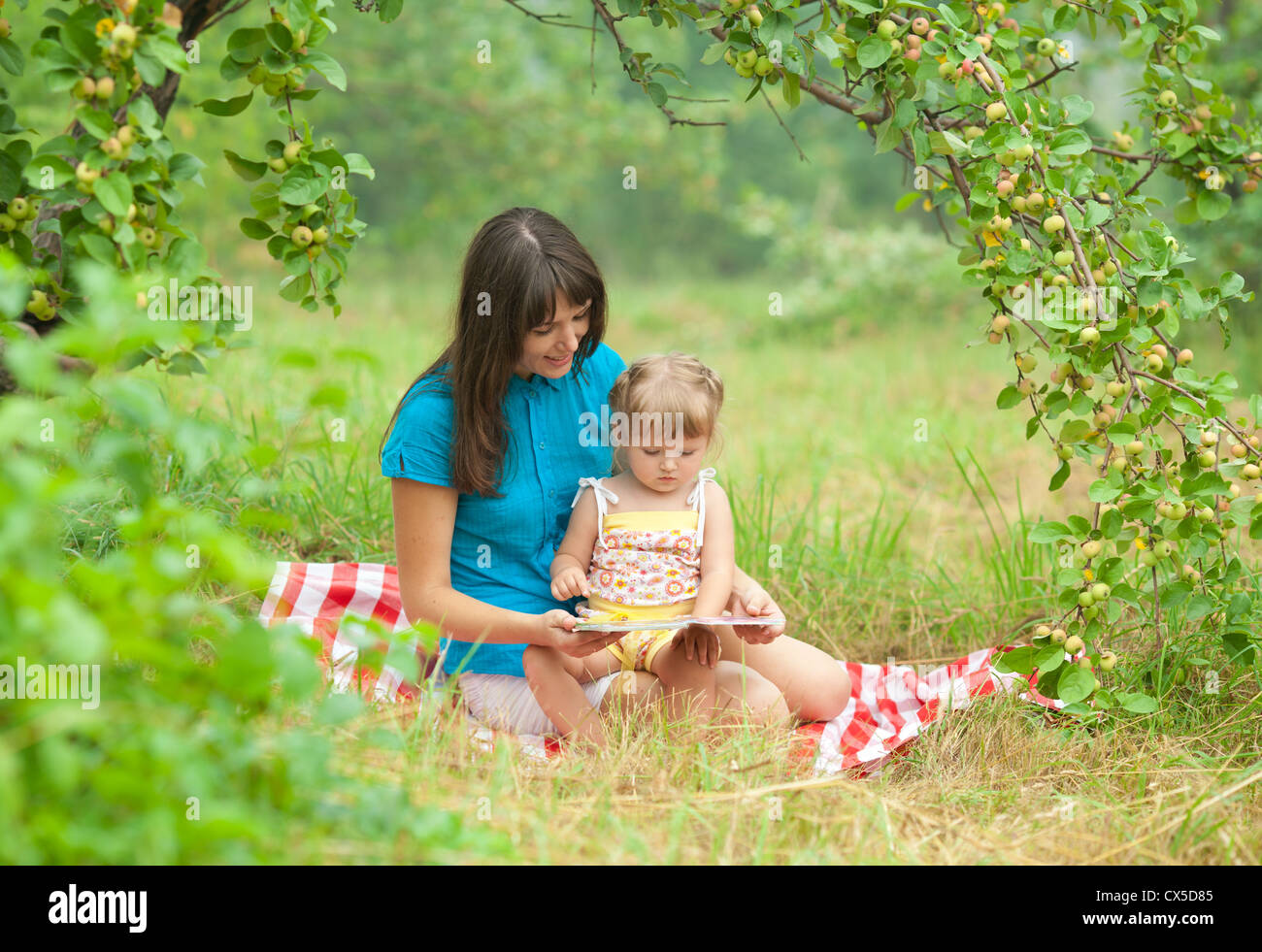 Mutter und Tochter lesen buchen Sie zusammen im freien Stockfoto