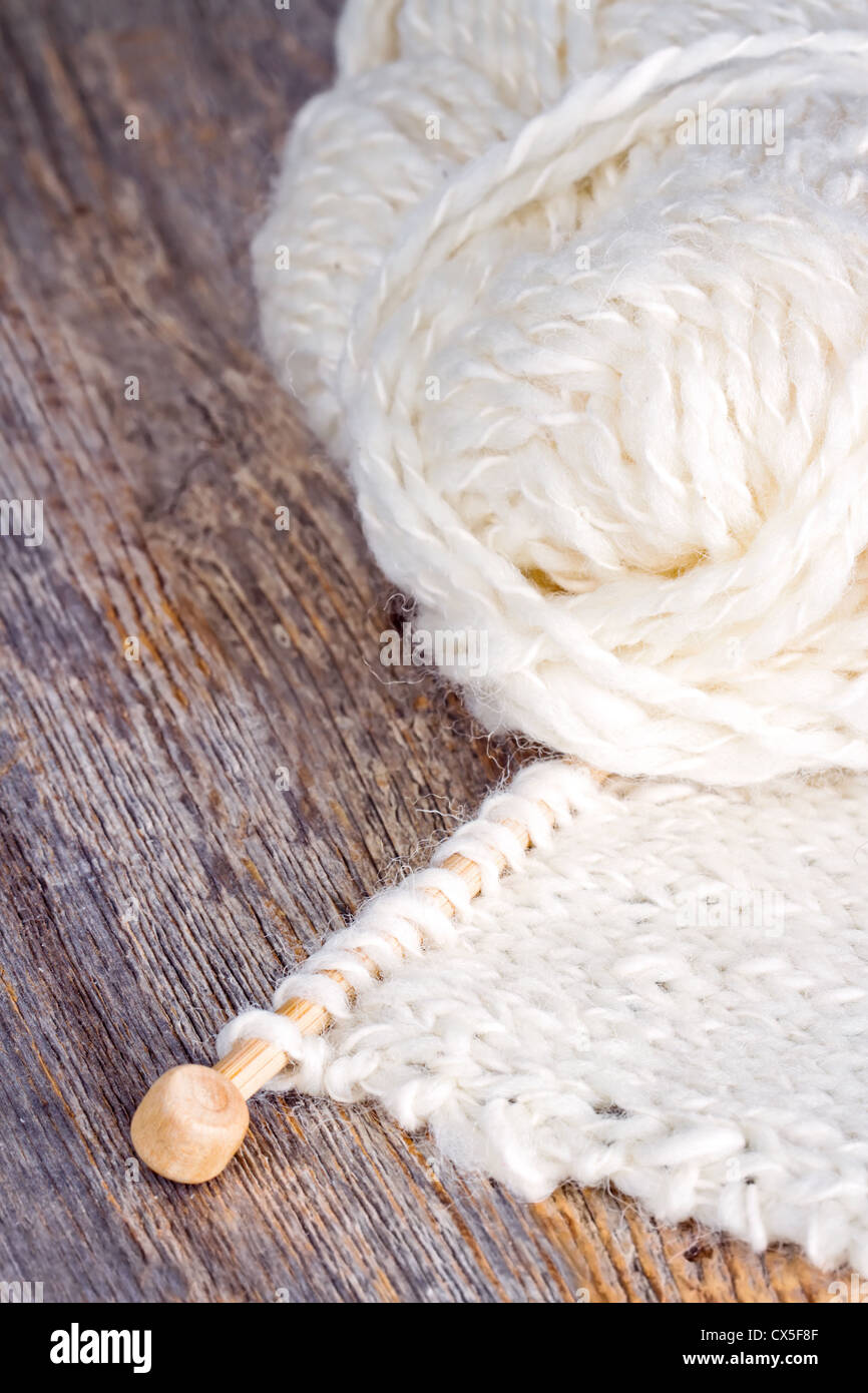 Weiße Strick- und hölzerne Nadeln auf rustikalen Hintergrund Stockfoto