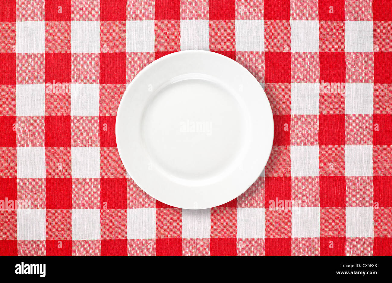 weißen Teller auf roten aufgegebenes Tischdecke Stockfoto