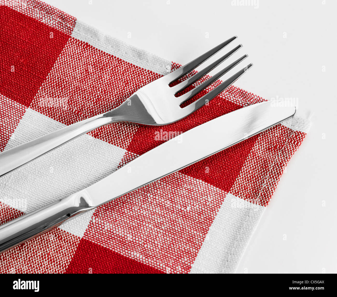 Messer und Gabel auf roten aufgegebenes Tischdecke Stockfoto