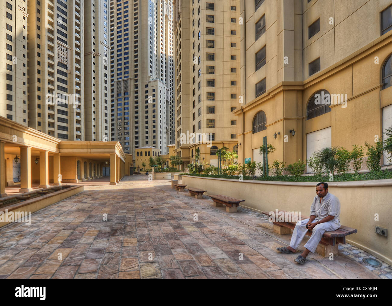 Ein Mann sitzt vor viele Blöcke von brandneuen Apartments in Dubai, Vereinigte Arabische Emirate. Stockfoto
