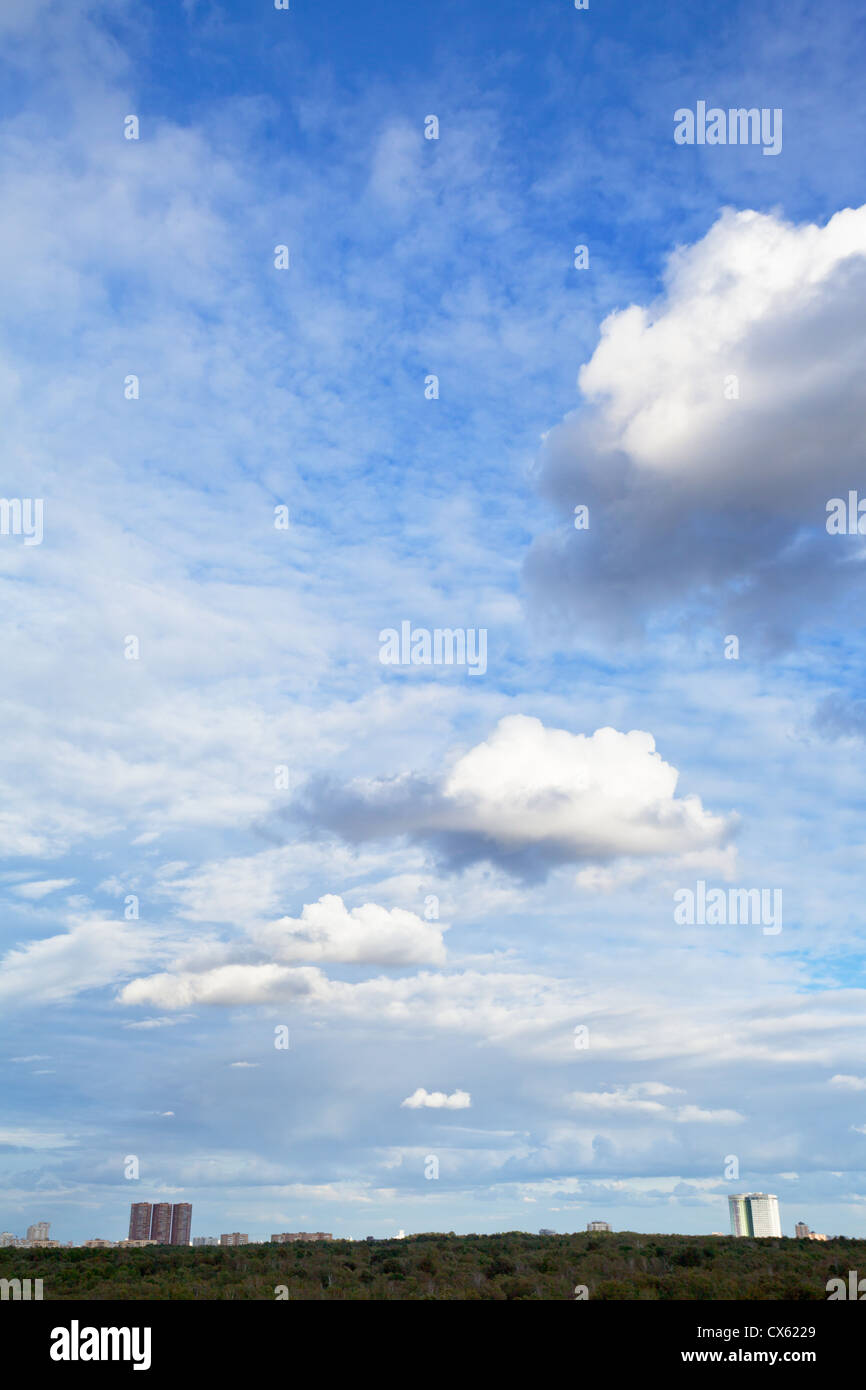 mehrere weiße Cumulus-Wolken unter Stadt am Nachmittag Stockfoto