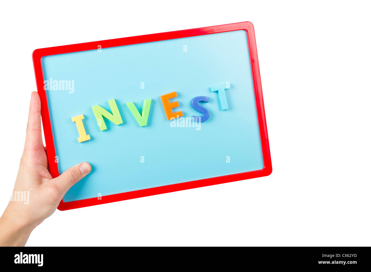 Wort "Invest" mit Magnetbuchstaben auf eine Kinder-Magnettafel ausgeschrieben. Stockfoto