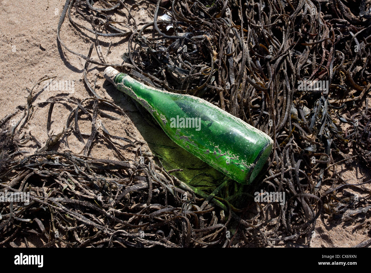 Grüne Flasche angespült Bigbury-On-Sea Beach, South Devon, England, Großbritannien Stockfoto