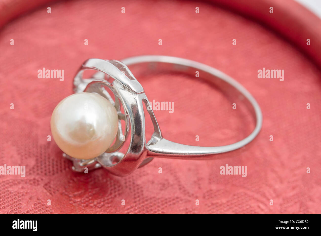 Perlenring Closeup auf rotem Grund Stockfoto